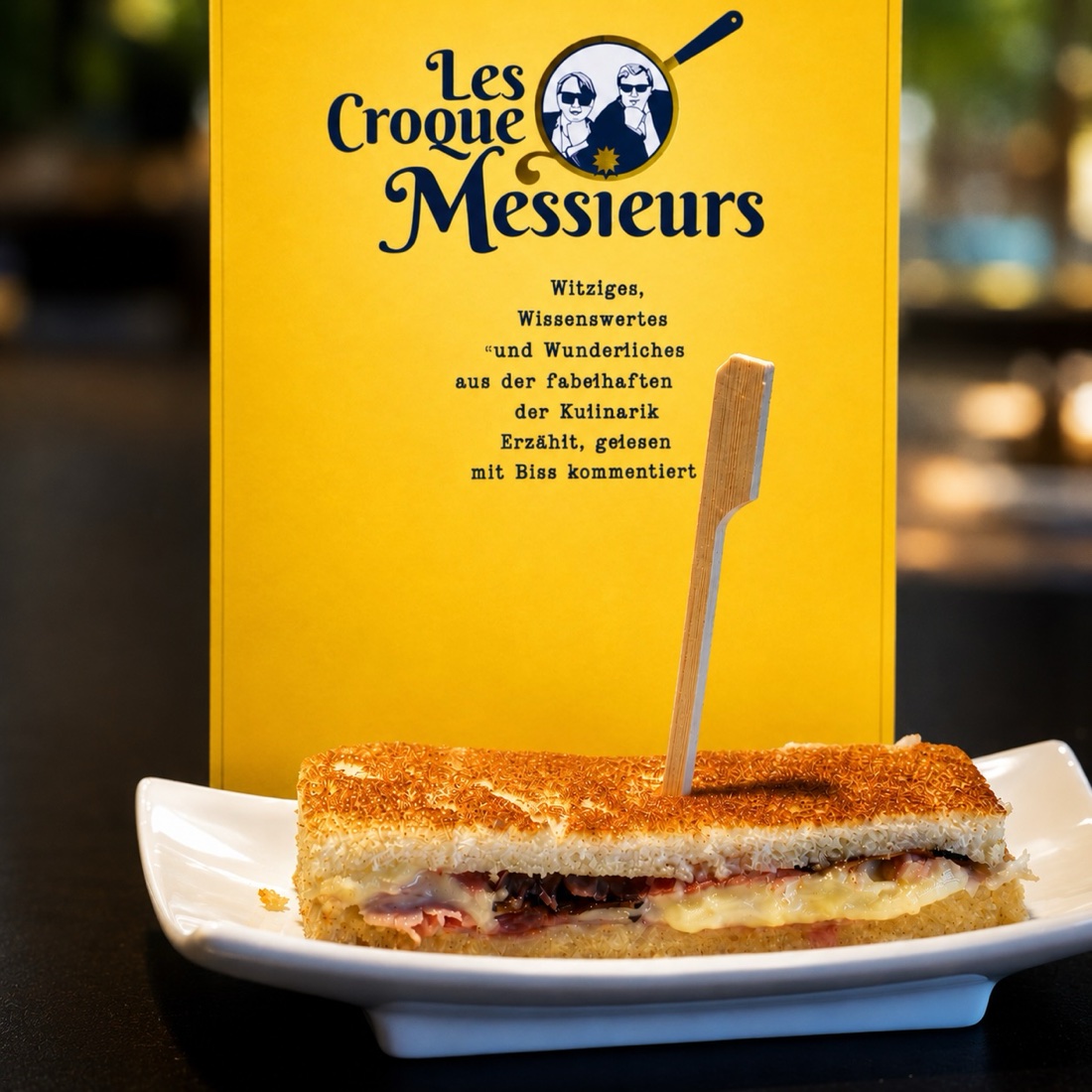 Ein Croque Monsieur vor der Programmkarte von Les Croque Messieurs